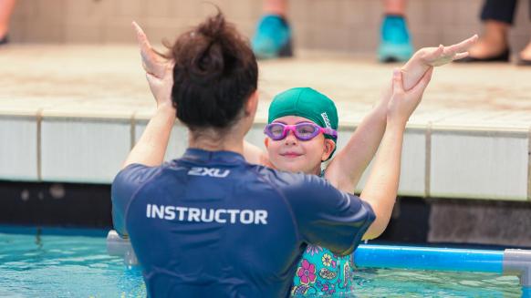 PerfectGym Swim School lesson plan instructor helping a student