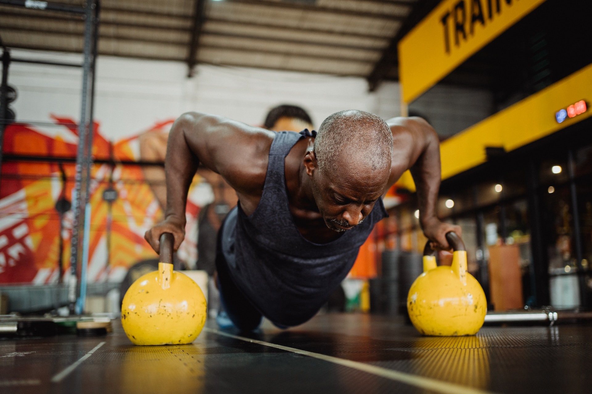 Homme faisant des pompes avec une kettlebell jaune