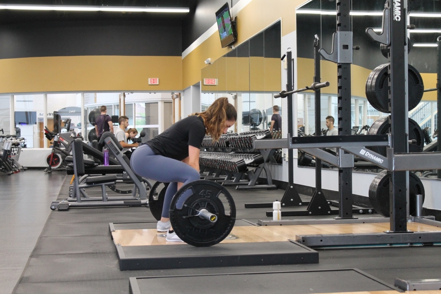 a woman lifting weights at an indoor gym