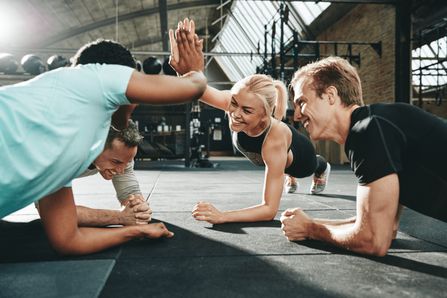 group of people doing plank and giving high five